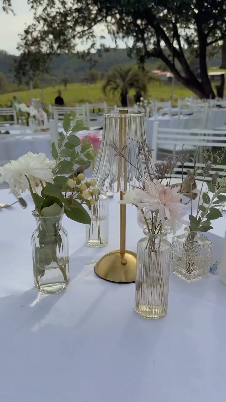 Mesa posta com flores e luminária